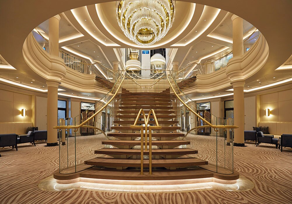 wooden staircase with a grand chandelier in atrium on Seven Seas Splendor